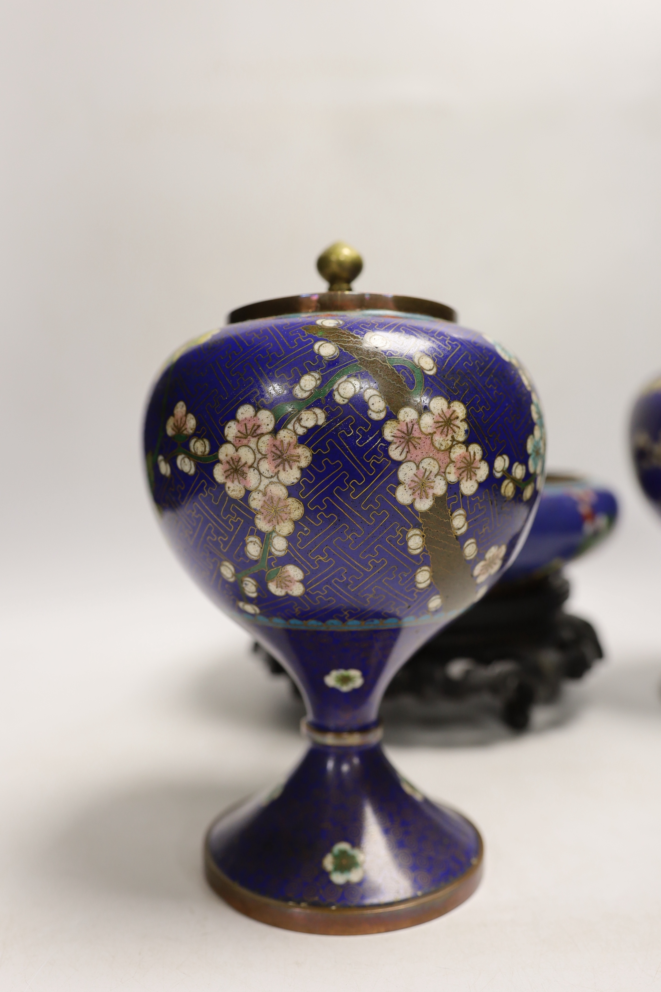 A pair of early 20th century Chinese cloisonné enamel jars and covers, together with a similar bowl and wood stand, largest 20cm high